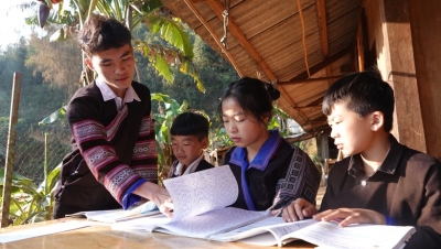 Sùng A Chua (ngoài cùng bên trái) đang hướng dẫn các em nhỏ ôn bài trong đợt nghỉ Tết nguyên đán Giáp Thìn.