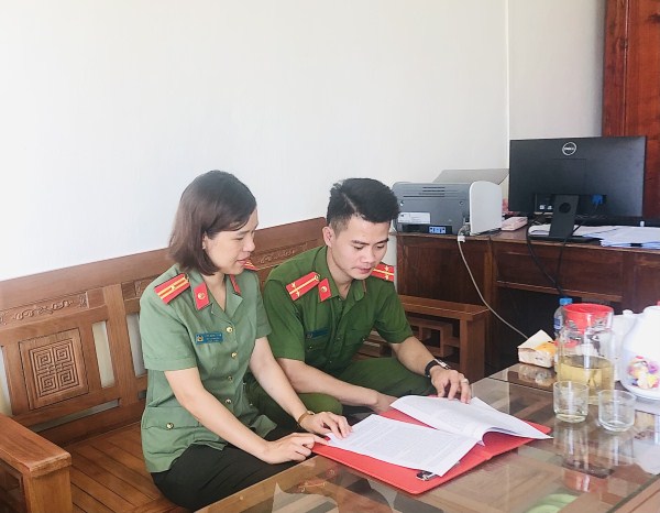 Thiếu tá Nông Hồng Thắm trao đổi nghiệp vụ với đồng nghiệp.