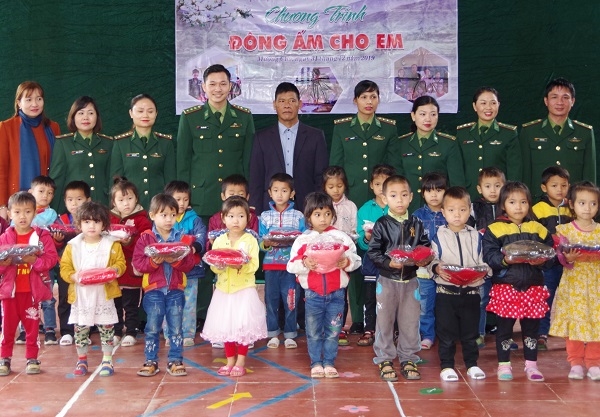 Đồng chí Đỗ Xuân Điềm (thứ tư, trái sang) tham gia tặng quà cho trẻ em khu vực biên giới (Ảnh: MH).