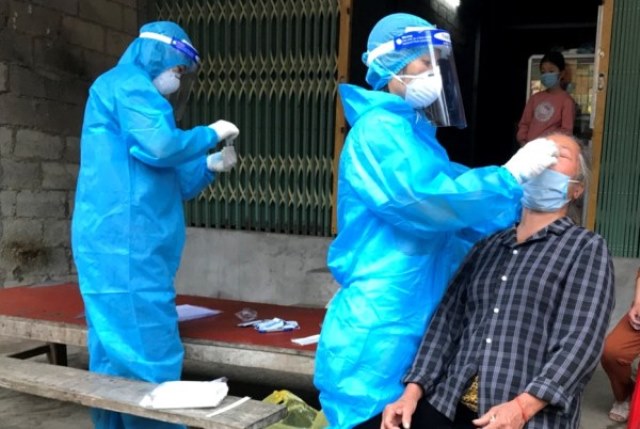 Nhân viên y tế lấy mẫu xét nghiệm sàng lọc SARS-CoV-2 tại phố Thông Huề, xã Đoài Dương (Trùng Khánh) ngay sau khi phát hiện F0 tại địa phương.