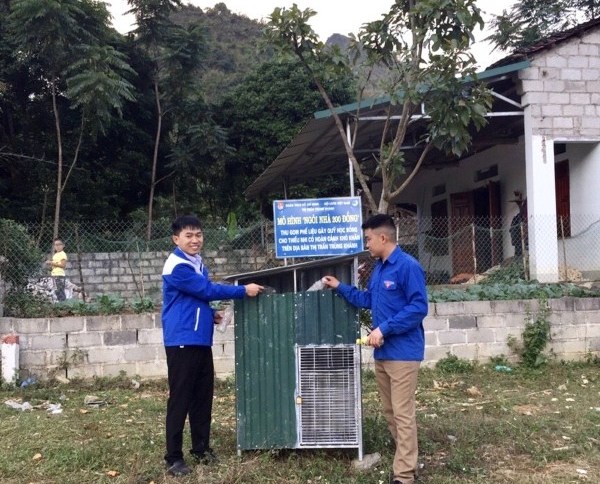 Anh Nông Văn Hoạt (bên trái) với mô hình “Ngôi nhà 200 đồng” thu gom phế liệu gây quỹ học bổng cho thiếu nhi.