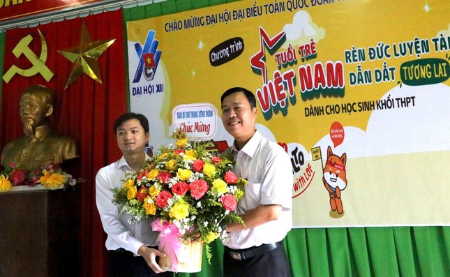Anh Nguyễn Minh Triết tặng hoa chúc mừng thầy cô giáo Trường THPT Dân tộc nội trú Nam Trà My.