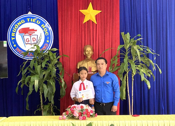 Anh Đỗ Duy Nam, Phó Bí thư Tỉnh Đoàn Gia Lai trao huy hiệu tuổi trẻ dũng cảm cho em Rơ Chăm Ư