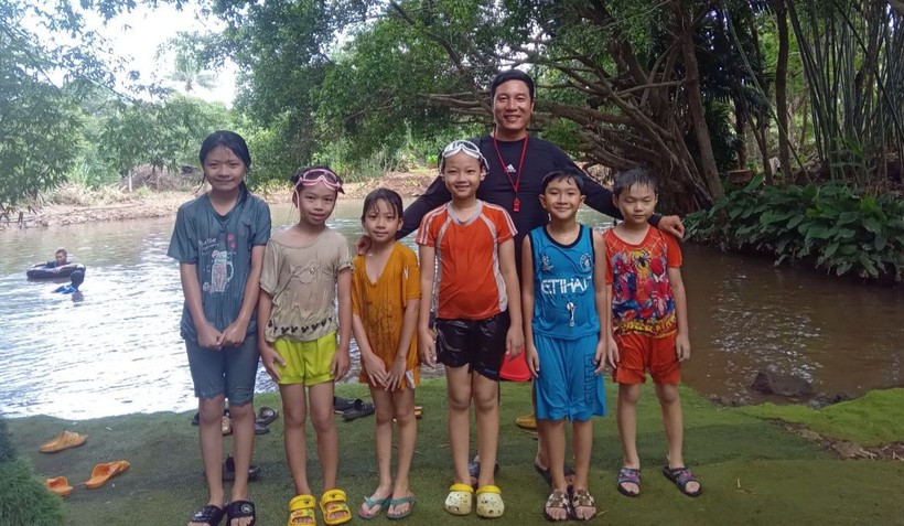 Thầy Hoàng Ngọc Cường với nhóm trẻ tại một lớp học bơi ở suối